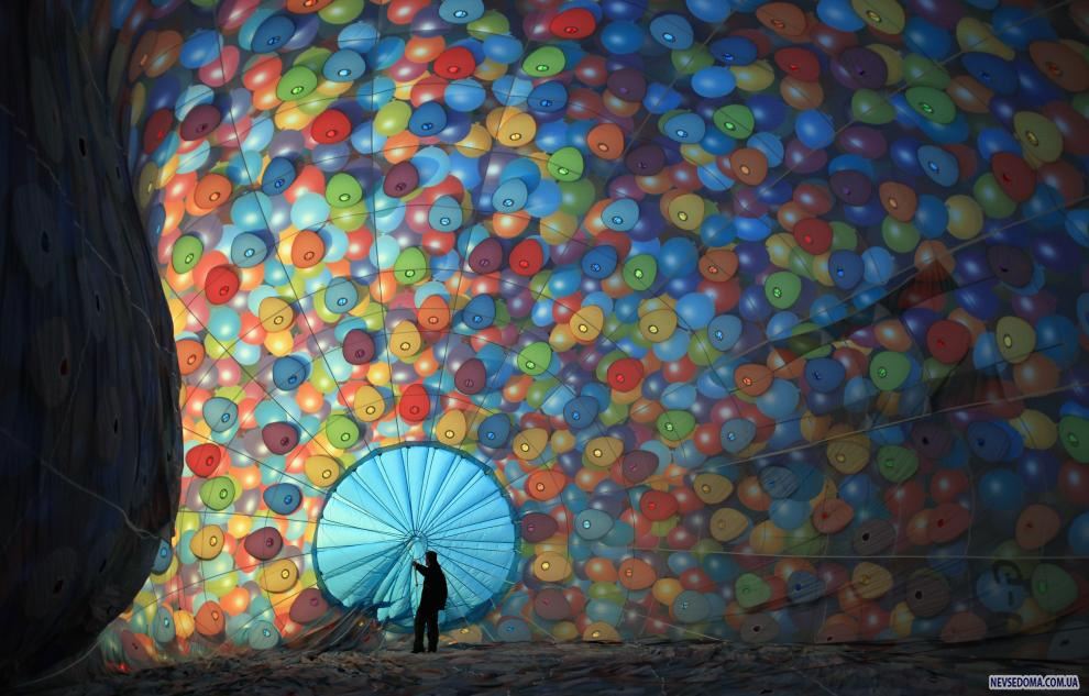 1) Мужчина проверяет веревки внутри воздушного шара во время подготовки к самому большому в Европе фестивалю воздушных шаров. (Matt Cardy/Getty Images News/ fotobank.ua / 7 августа 2009/ Англия, Бристоль)