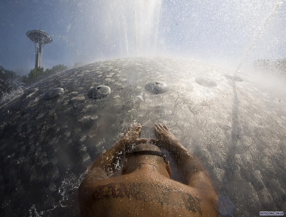 5) Мужчина охлаждается в фонтане. В Сиэтле была зафиксирована рекордная температура +39° C. (Stephen Brashear/Getty Images News/ fotobank.ua / 29 июля 2009/ США, Сиэтл)
