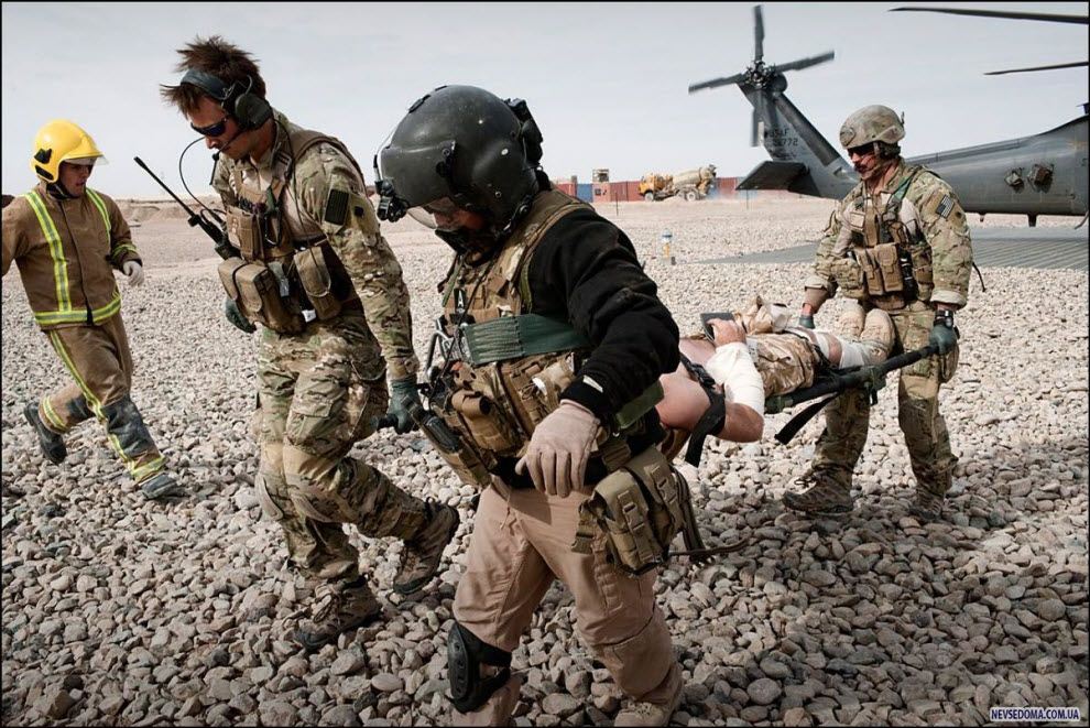 12)   .US Air Force Pedro Med Evac personnel carry a stretcher with a wounded British soldier from their helicopter into an ambulance in Camp Bastion.